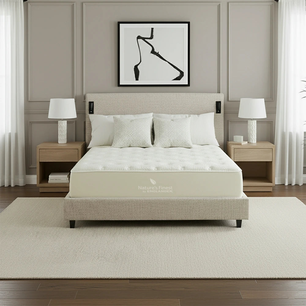 Beige bed with white bedding in a bedroom setting with lamps and artwork.