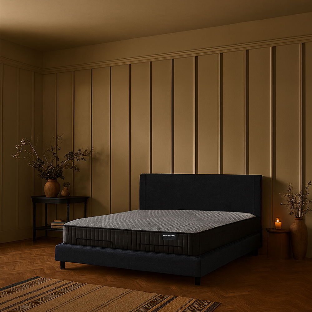 Black bed frame with mattress in a dimly lit bedroom