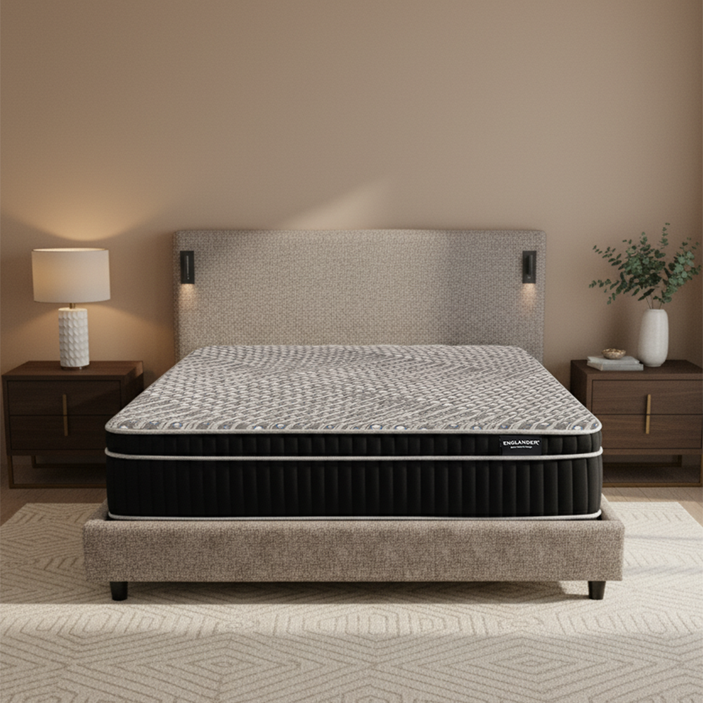 Gray mattress on a bed frame in a bedroom setting with nightstands and a lamp.
